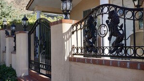 A gated entrance with decorative metalwork and a lamp post. - Beach house on the beach! (Ventura)
