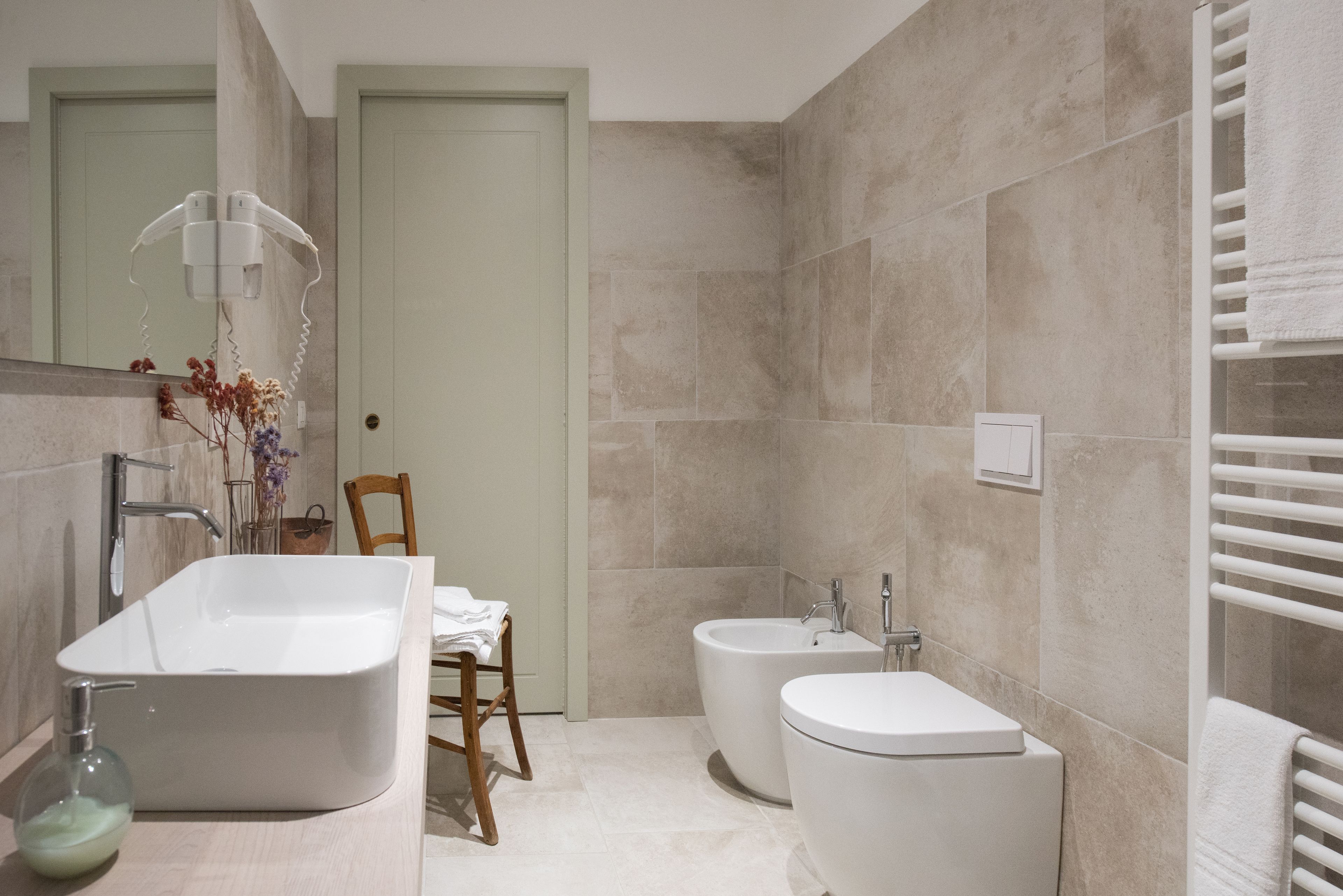 Un baño moderno con una bañera independiente, un inodoro estándar y un bidé.