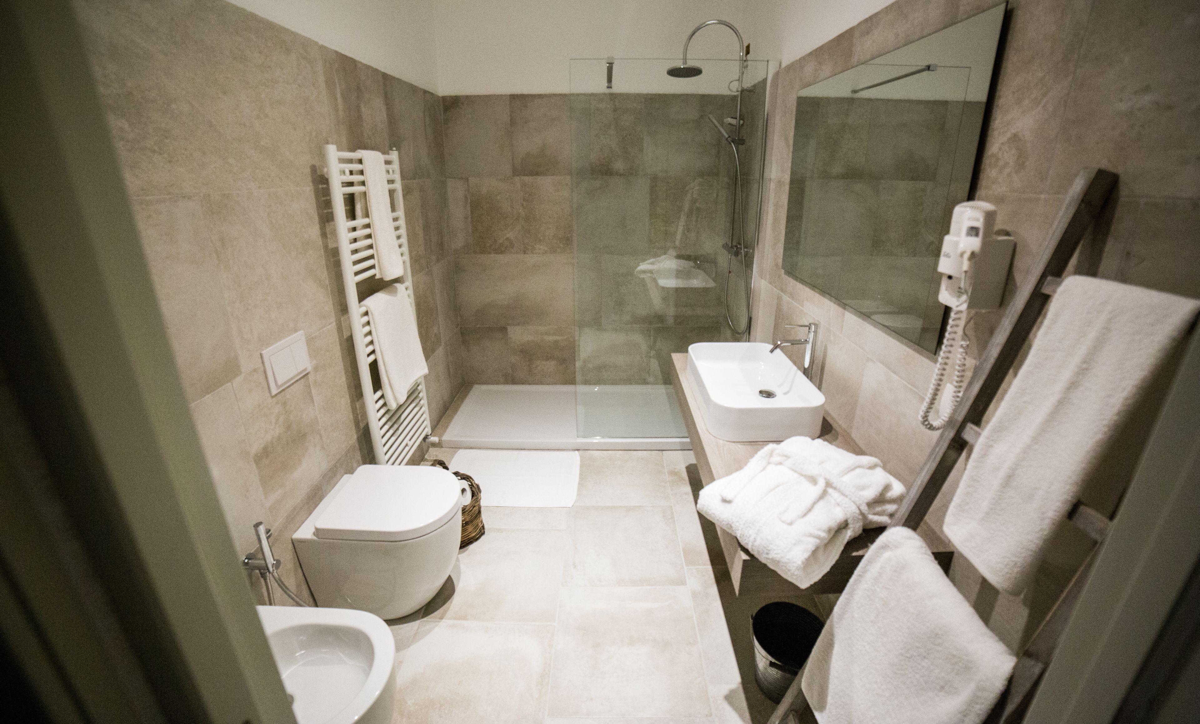Une salle de bain moderne équipée de toilettes, d’un bidet, d’une douche et d’un lavabo.