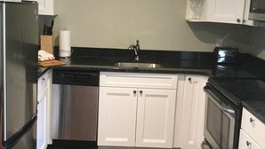 A kitchen with white cabinets, a stainless steel refrigerator, a dishwasher, a microwave, and a stove. - comfort, luxury, privacy (Amherst)