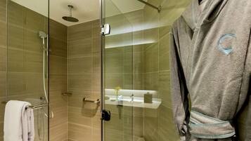 A modern bathroom with a glass shower enclosure, a towel rack, and a vanity with a mirror.