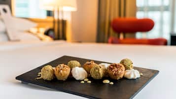 A dessert plate with various sweets on a slate board in a hotel room.