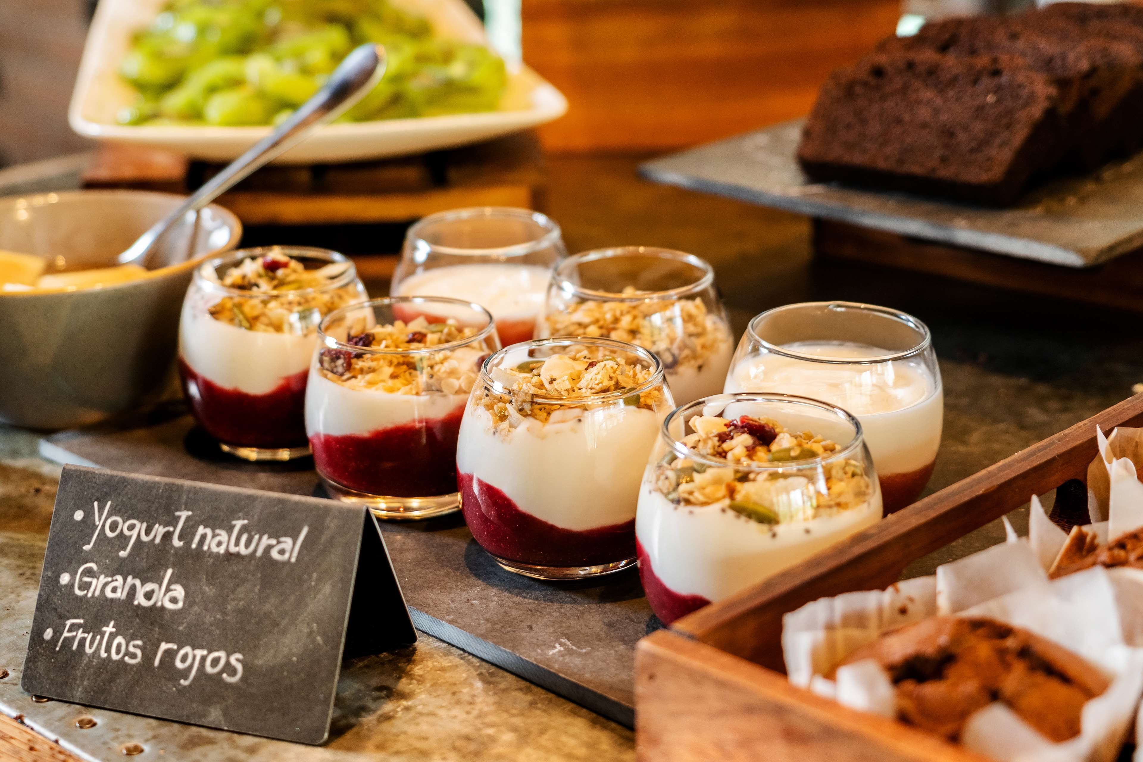 A dessert display with yogurt, granola, and red fruits.