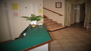 A hallway with a green counter, a staircase, and a door.