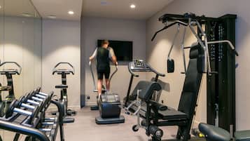A gym with treadmills, dumbbells, and weight machines.