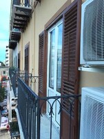 Un edificio residenziale con balconi, persiane marroni e condizionatori.