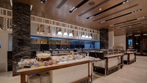 A modern hotel buffet with marble columns, multiple serving stations, and a clean, contemporary design. - Courtyard by Marriott Surat (Surat)
