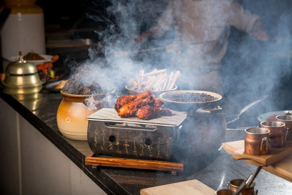 Une cuisine équipée d’un barbecue, de casseroles et d’ustensiles de cuisine.