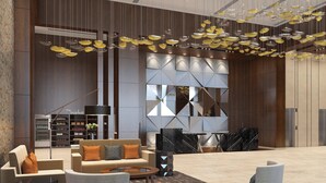 A modern lobby with a sofa, coffee table, and geometric wall design. - Courtyard by Marriott Surat (Surat)