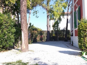 Stroll through the tranquil tree-lined street to this traditional building with a charming red facade and green shutters.