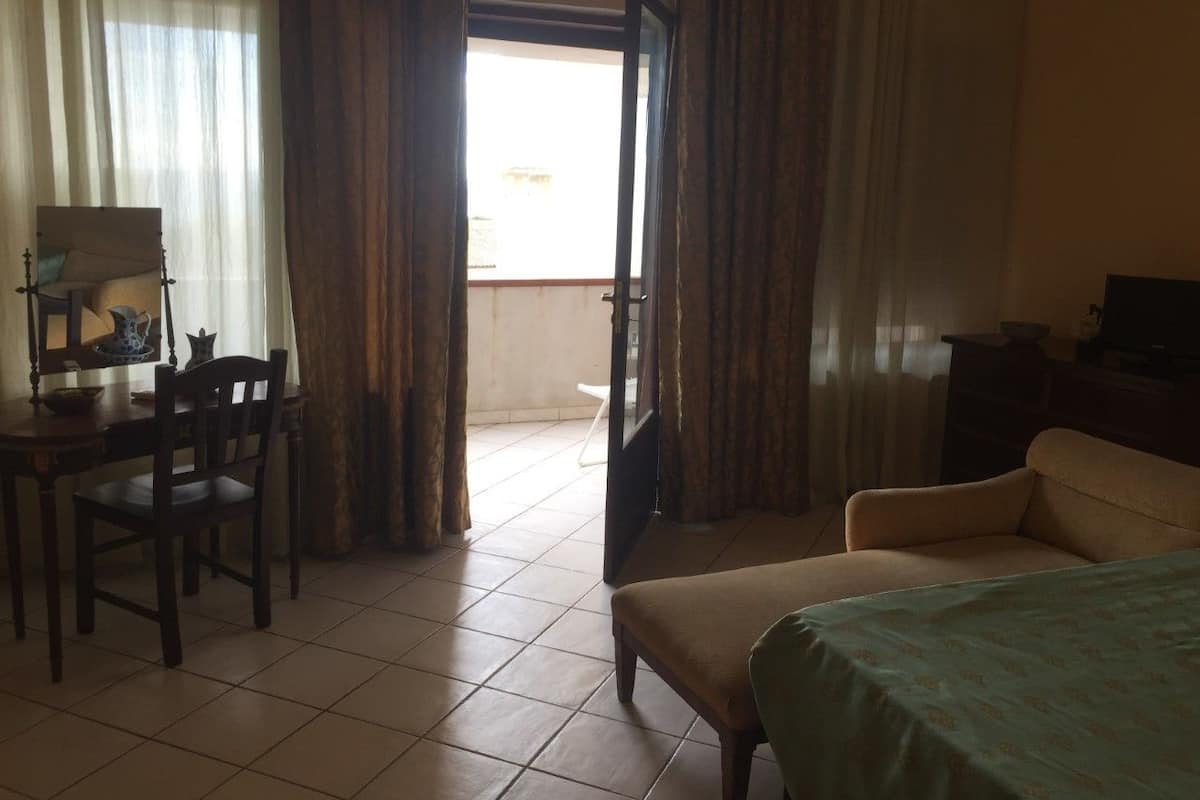 Une chambre d’hôtel comprenant un lit, un bureau avec une chaise, une télévision et une vue sur l’extérieur.