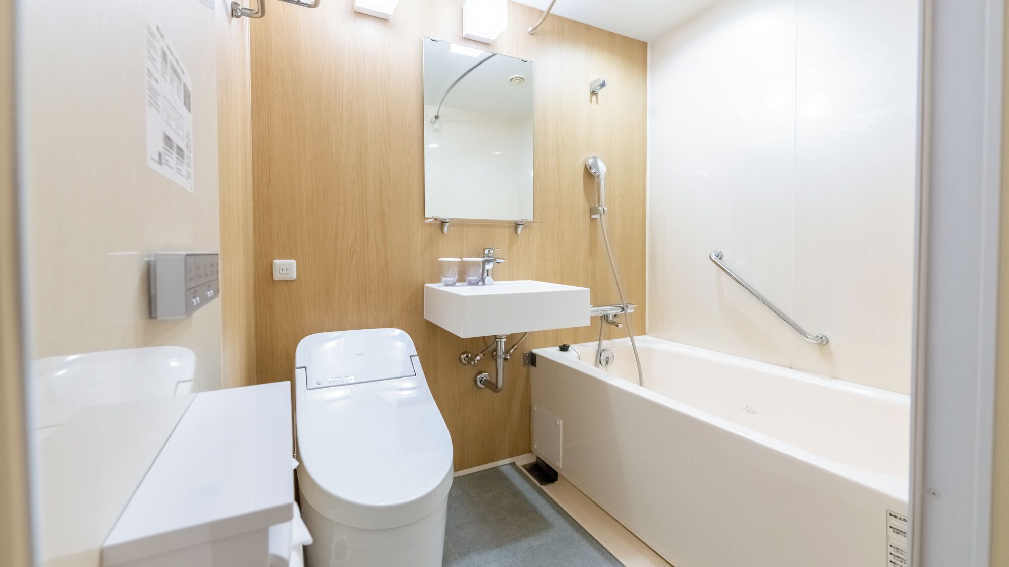 A modern bathroom with a toilet, sink, and bathtub.