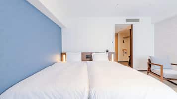 Quarto de hotel moderno com uma cama grande, abajures, uma cabeceira de madeira e uma cadeira.