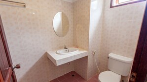 Ein Badezimmer mit einem weißen Waschbecken, Spiegel und Toilette.