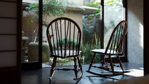 Two rocking chairs positioned near a large window with a view of a garden. - KYOTO Yadomachi Nishijin (Kyoto)