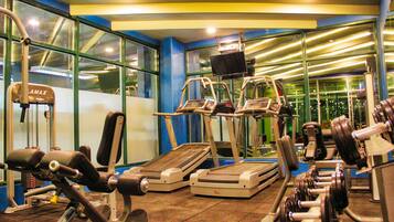 A gym with treadmills, weight machines, and a mirror.