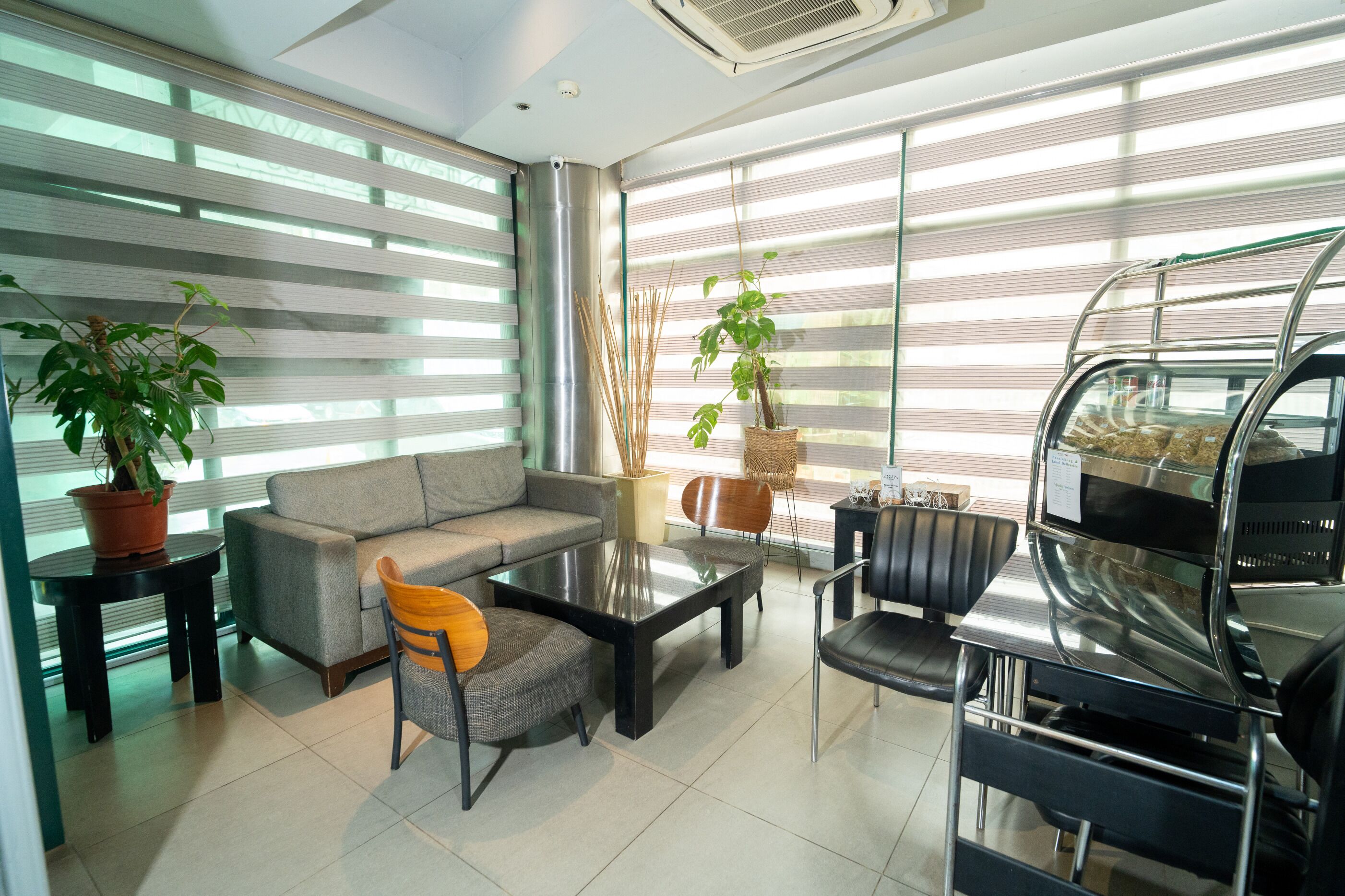 Un área de estar moderna con sofá, sillones, una mesa de centro y una estación de parrilla.