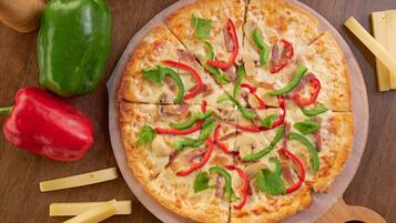 A pizza with various toppings on a wooden board.