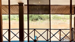 A room with a view of a river and greenery outside. - Merry Riverside Hotel (Luang Prabang)