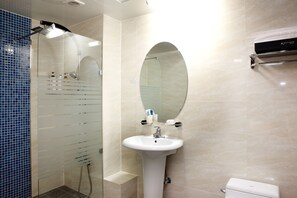 A bathroom with a glass-enclosed shower, a pedestal sink, and a toilet. - Ritz Castle Resort (Taean)