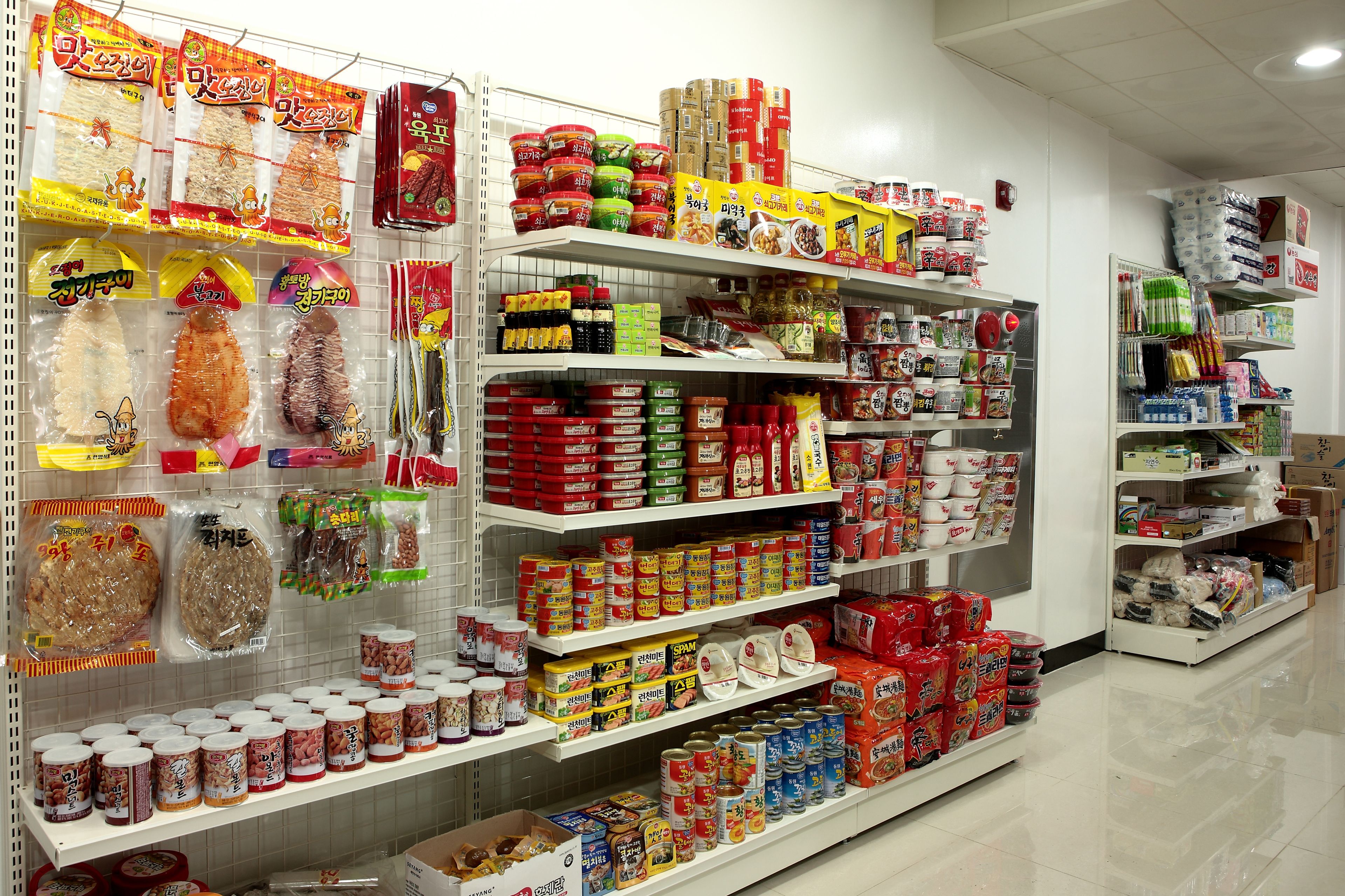 A grocery store aisle with various packaged food items and household goods.