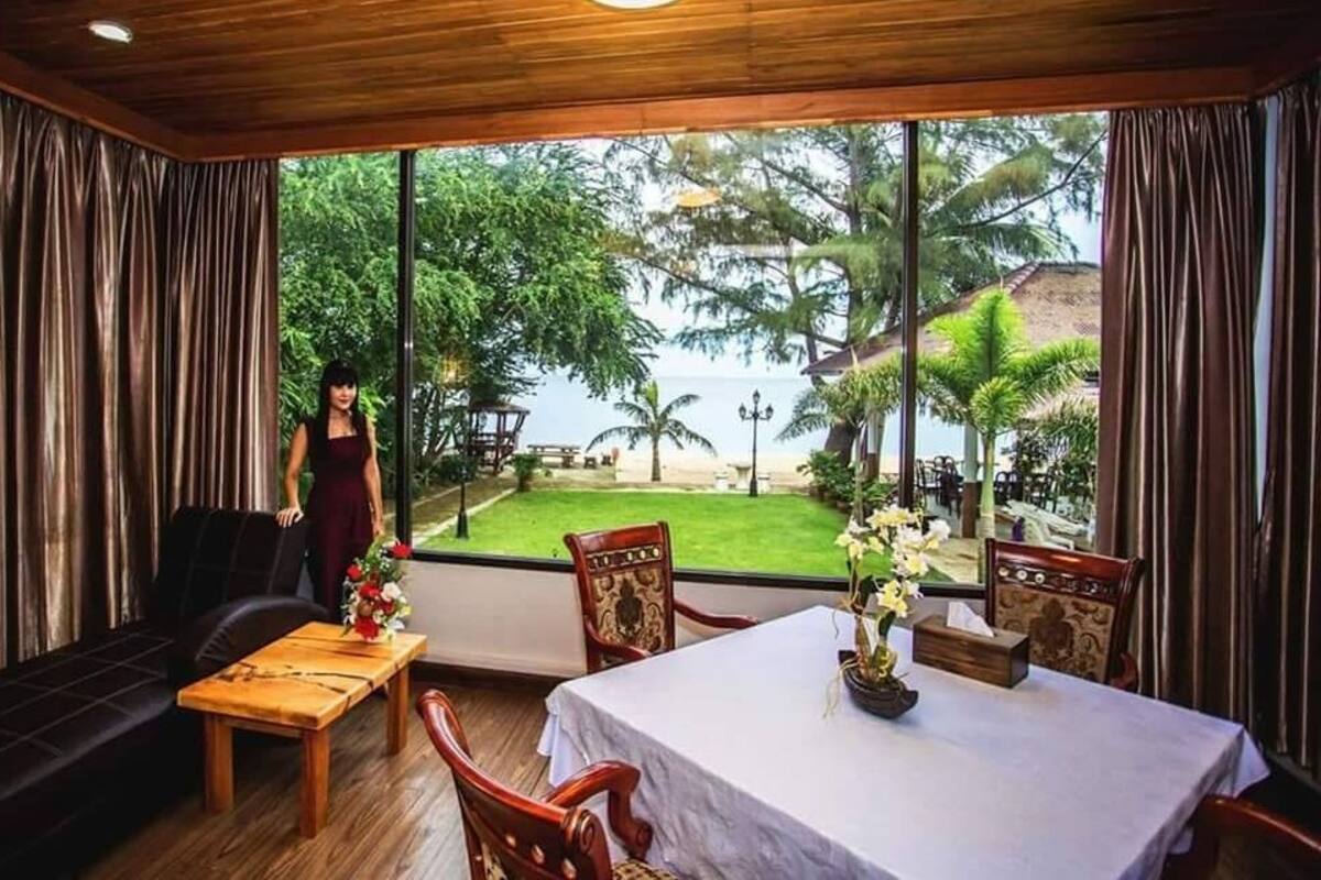 Una habitación con un ventanal grande, un sofá, una mesa y una silla.