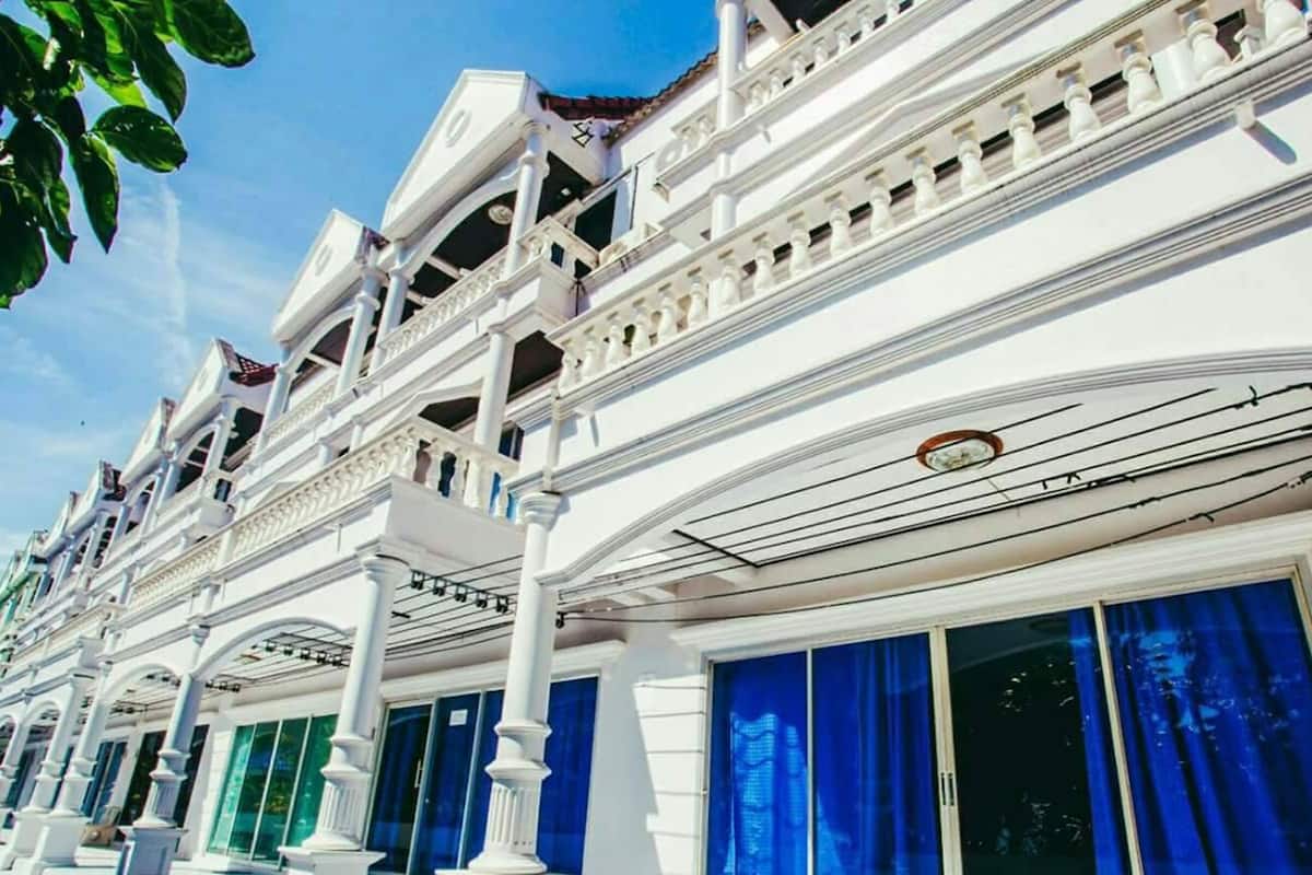 Un hotel de varios pisos con balcones y ventanas amplias.