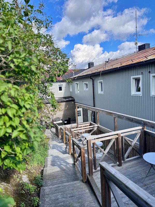 A wooden deck leading to a building with multiple windows and a metal roof. - Kramfors Stadshotell (Kramfors)