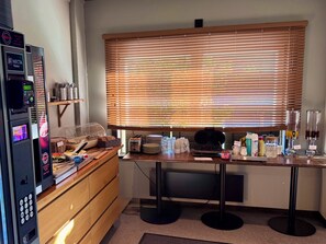 A kitchenette with a coffee machine, toaster, and various kitchen items on the counter. - Kramfors Stadshotell (Kramfors)