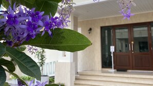 A building with a beige facade, a wooden door, and a tiled entrance area. - Siam Tharadol (Bangkok)