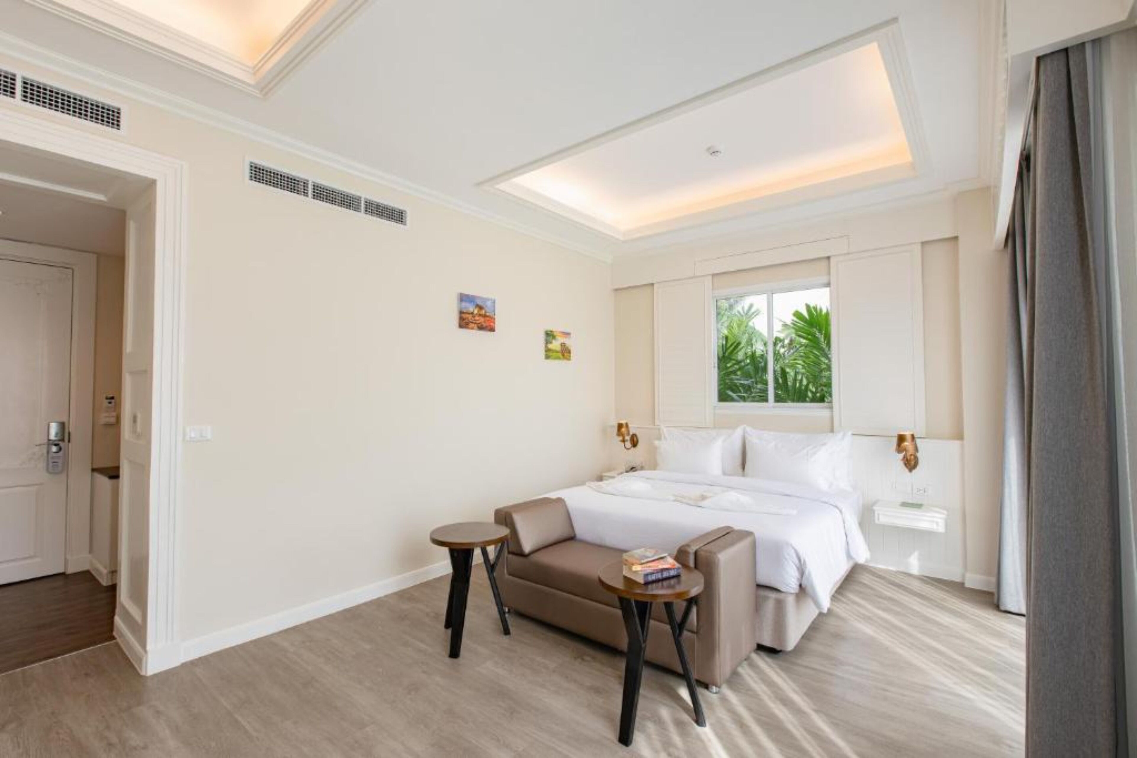 Une chambre d’hôtel avec un lit, un canapé, une petite table et une table de chevet.