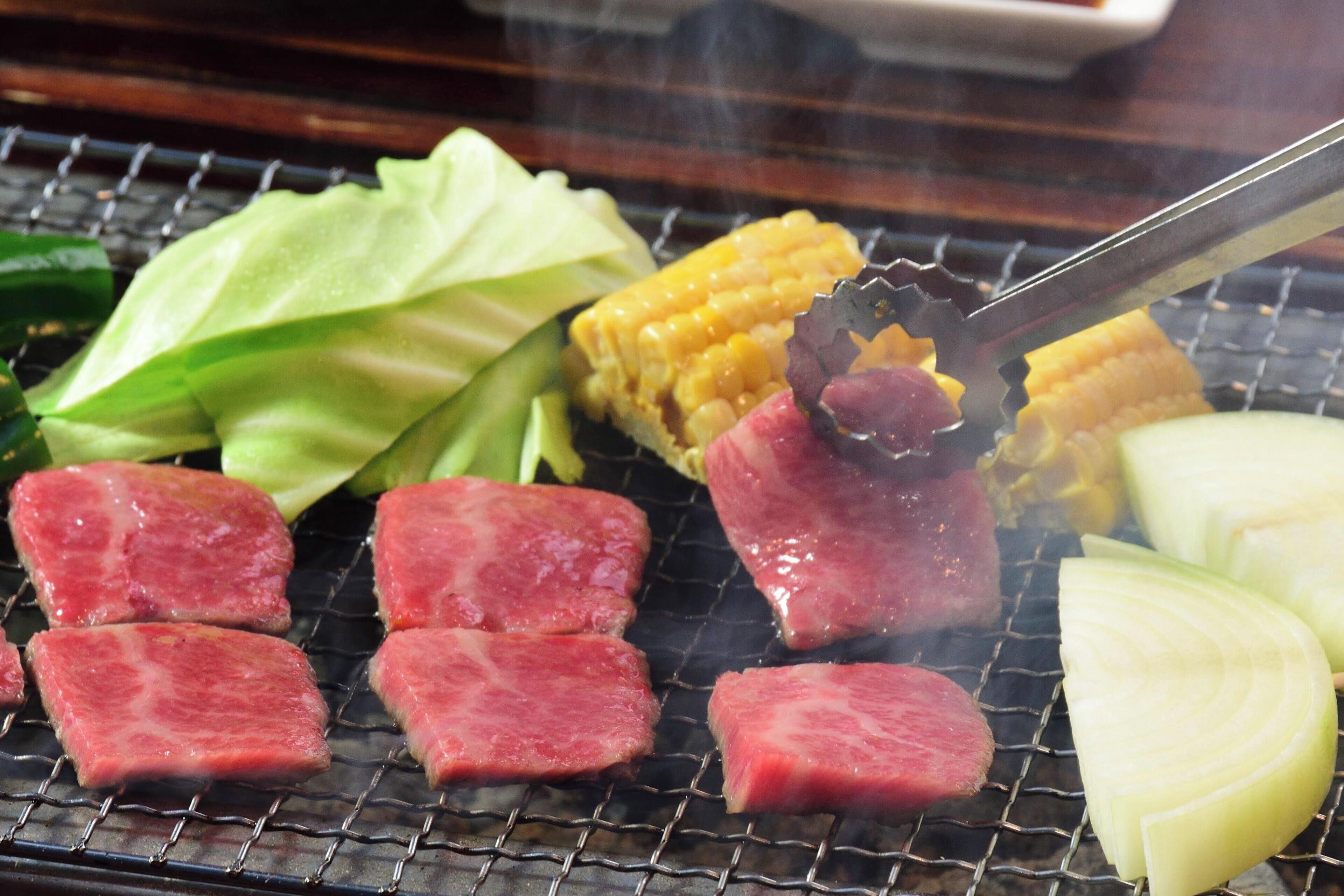 A grill with various meats and vegetables.