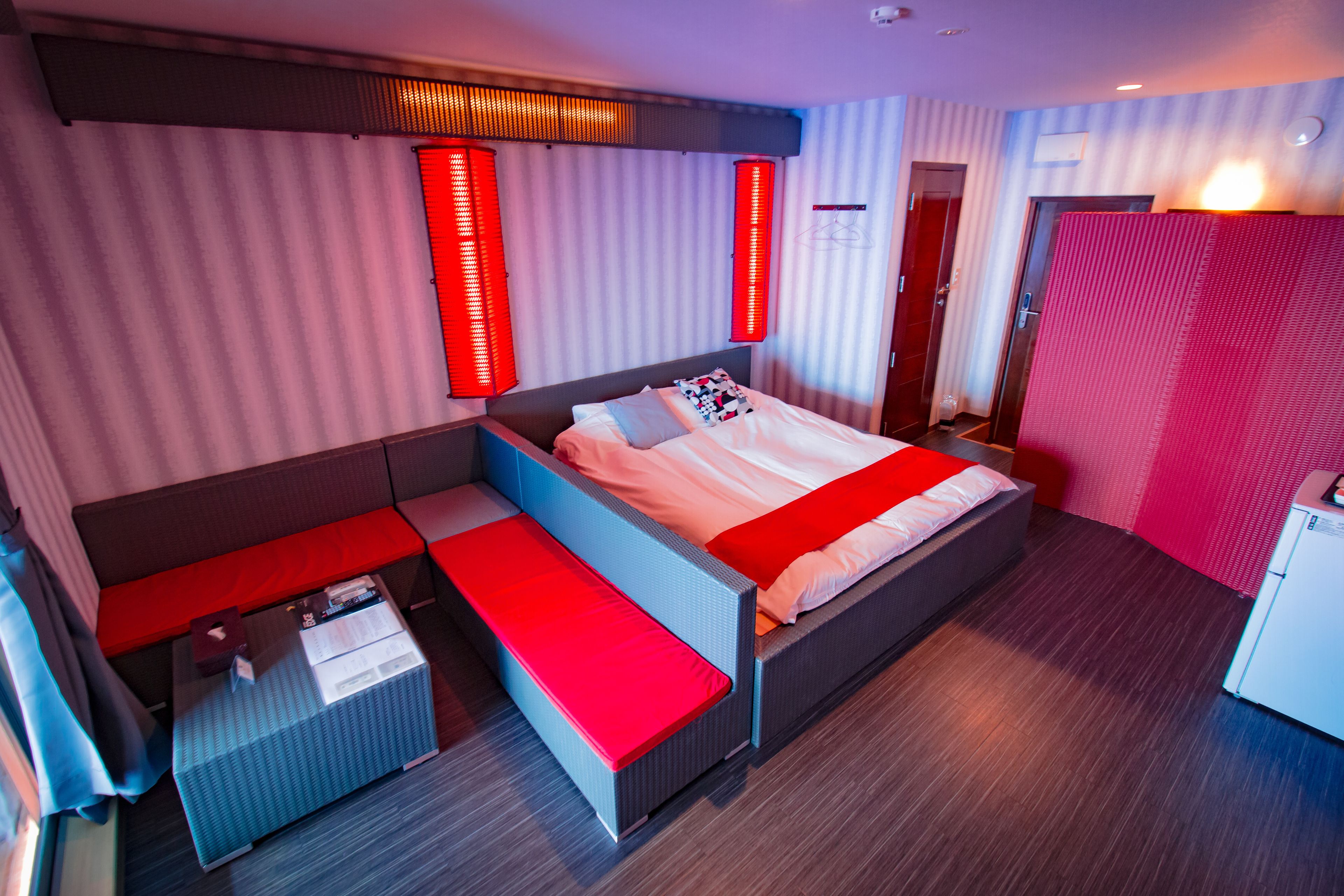 Quarto de hotel moderno com uma cama grande, um espaço de estar e uma pequena escrivaninha.