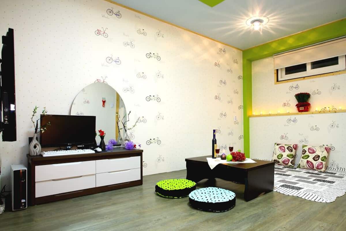 A modern living room with a TV, entertainment unit, and a small table with decorative items.