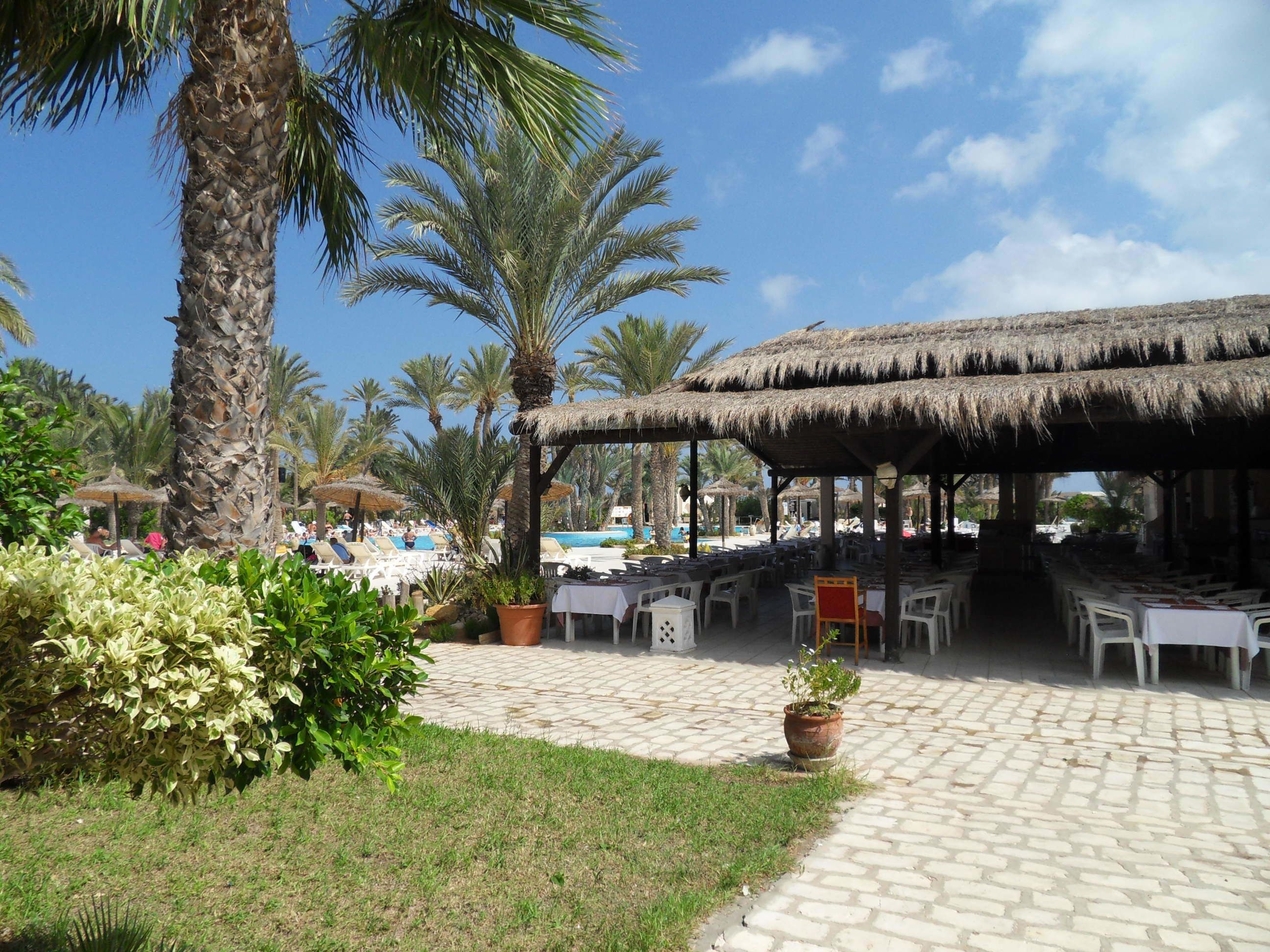 Ein Resort mit Außenbereich, Palmen und einem Pool.