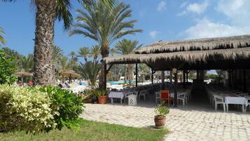 Ein Resort mit Außenbereich, Palmen und einem Pool.