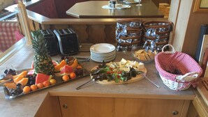 Un mostrador de buffet con una variedad de frutas, quesos y pan.