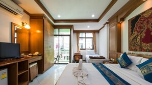 Una habitación de hotel con cama, escritorio, televisor y un ventanal grande.