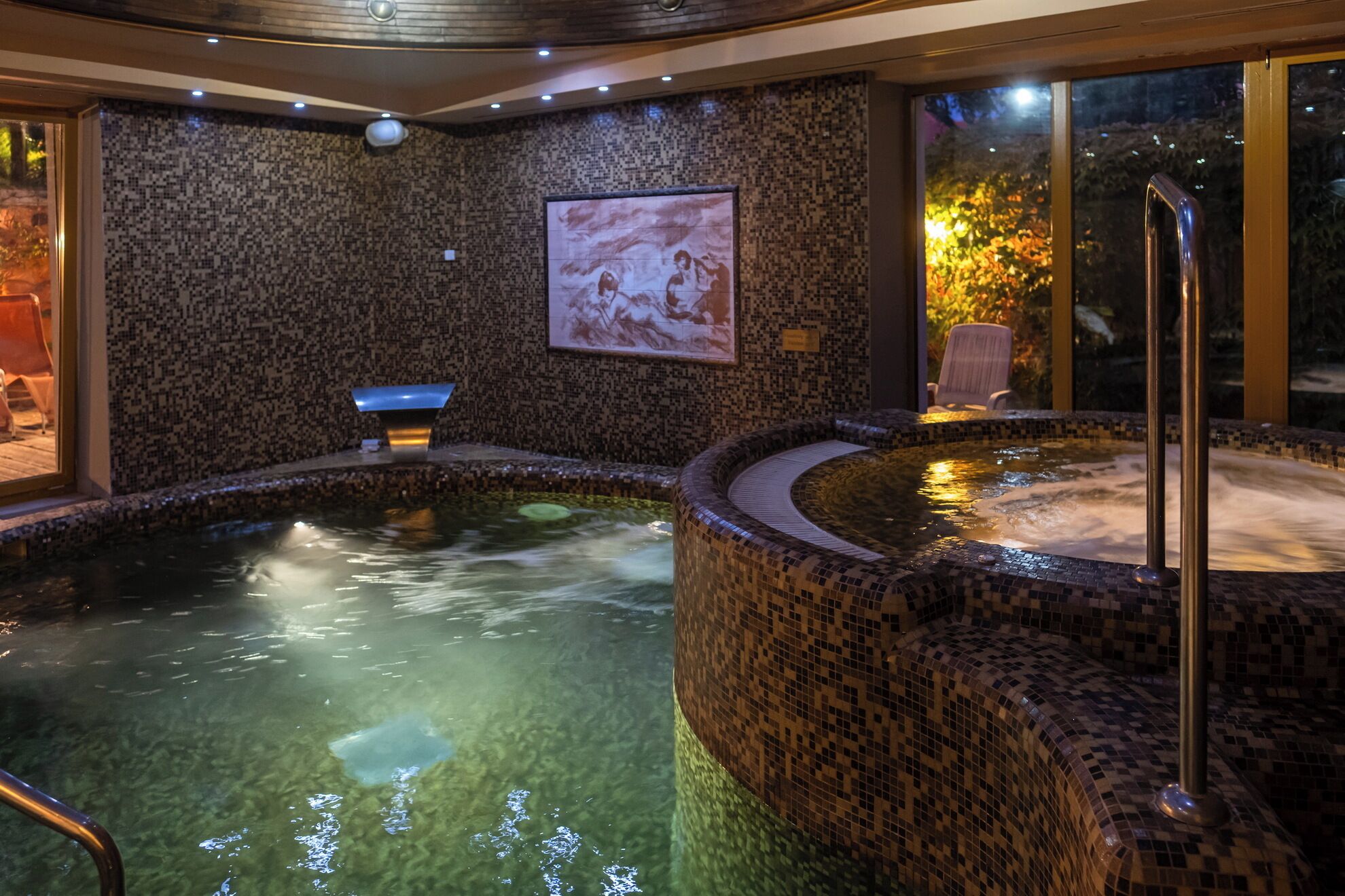 Una piscina techada, sillones reclinables de piscina