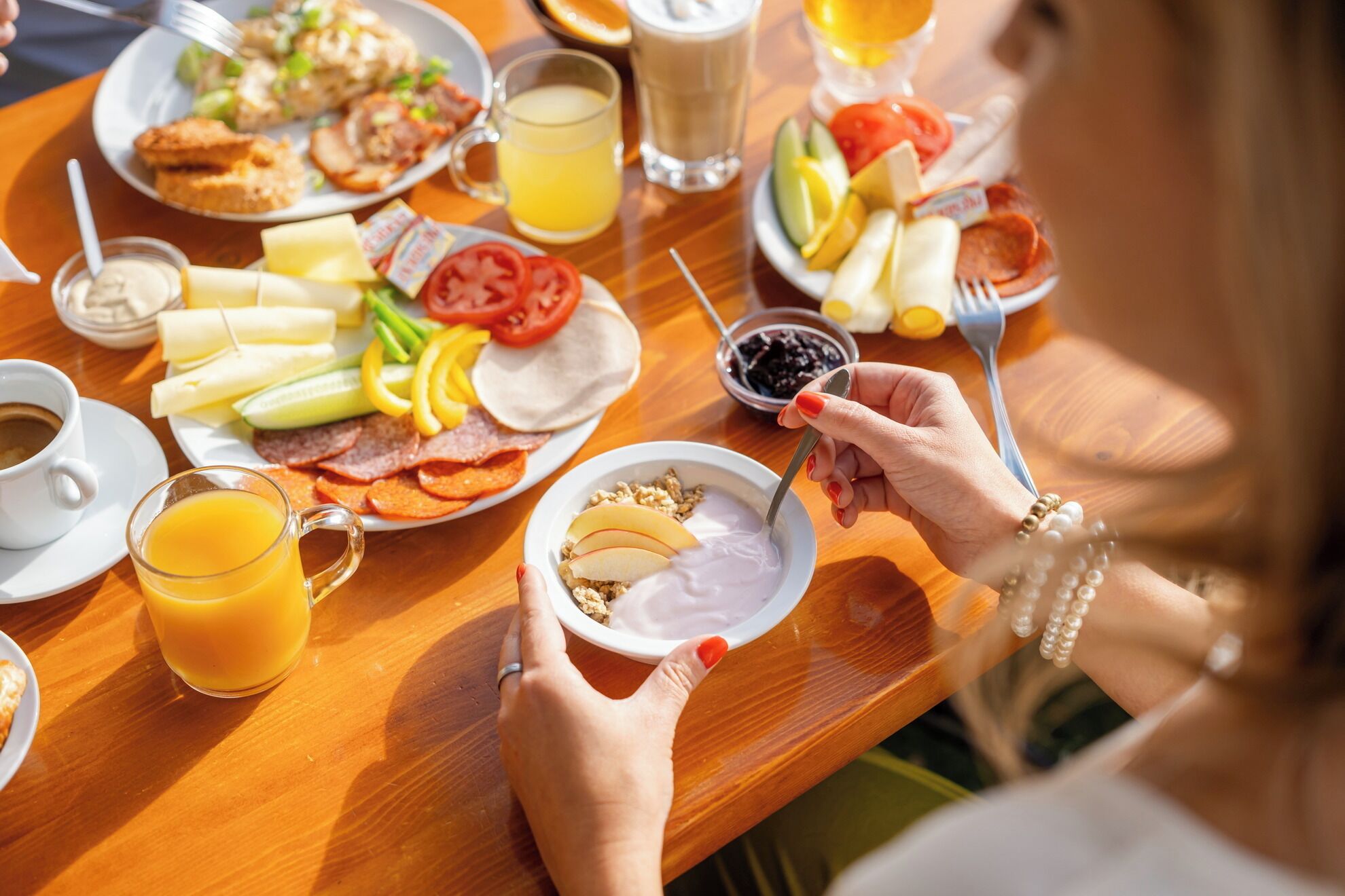 Une table en bois dressée pour le petit-déjeuner, avec divers aliments et boissons.