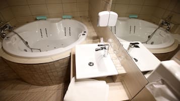 Un baño con dos tinas separadas, un lavabo y un espejo.