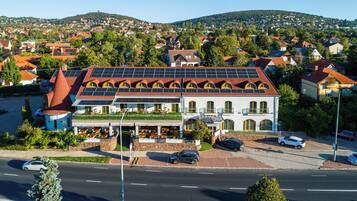 Een hotel met een rood dak, zonnepanelen en een restaurant op de begane grond.