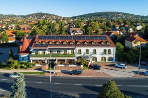 A hotel with a red roof, solar panels, and a restaurant on the ground floor. - Laroba Wellness Hotel (Alsoors)