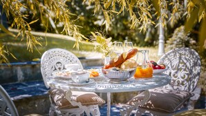 A round table with a white tablecloth, surrounded by ornate white chairs with cushions. - Park Hotel & Spa Katharina (Badenweiler)