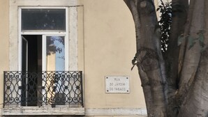 Un bâtiment doté d’un balcon, d’une porte et d’un arbre devant.