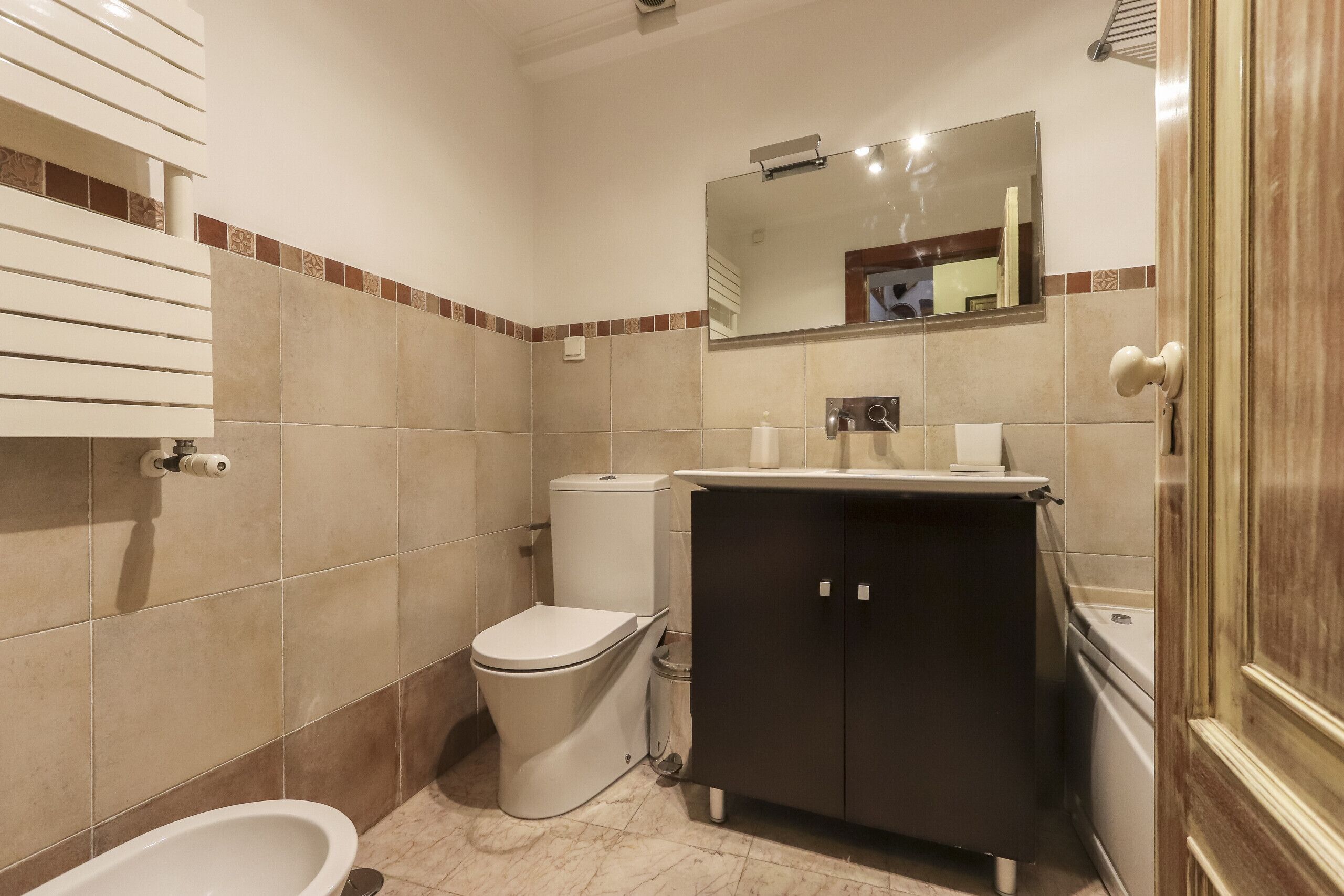A bathroom with a toilet, bidet, and sink.