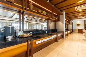 A buffet area with a long counter, multiple serving stations, and a variety of dishes displayed. - Grand Hotel Vientiane (Vientiane)