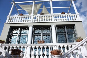 A building with white columns, large windows, and potted plants on the balcony. - B&B La Marchesa (Sant'Anastasia)