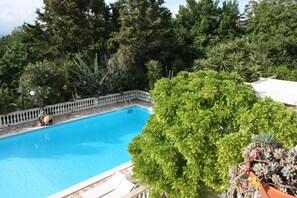 A swimming pool surrounded by lush greenery and a white fence. - B&B La Marchesa (Sant'Anastasia)