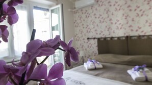 Un dormitorio con cama, lámpara colgante y un estampado floral en las paredes.